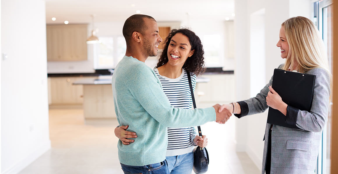 young couple meeting with real estate agent